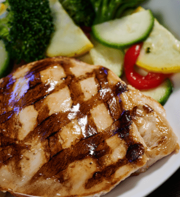 grilled chicken breast for kids with a side of veggies placed on a plate